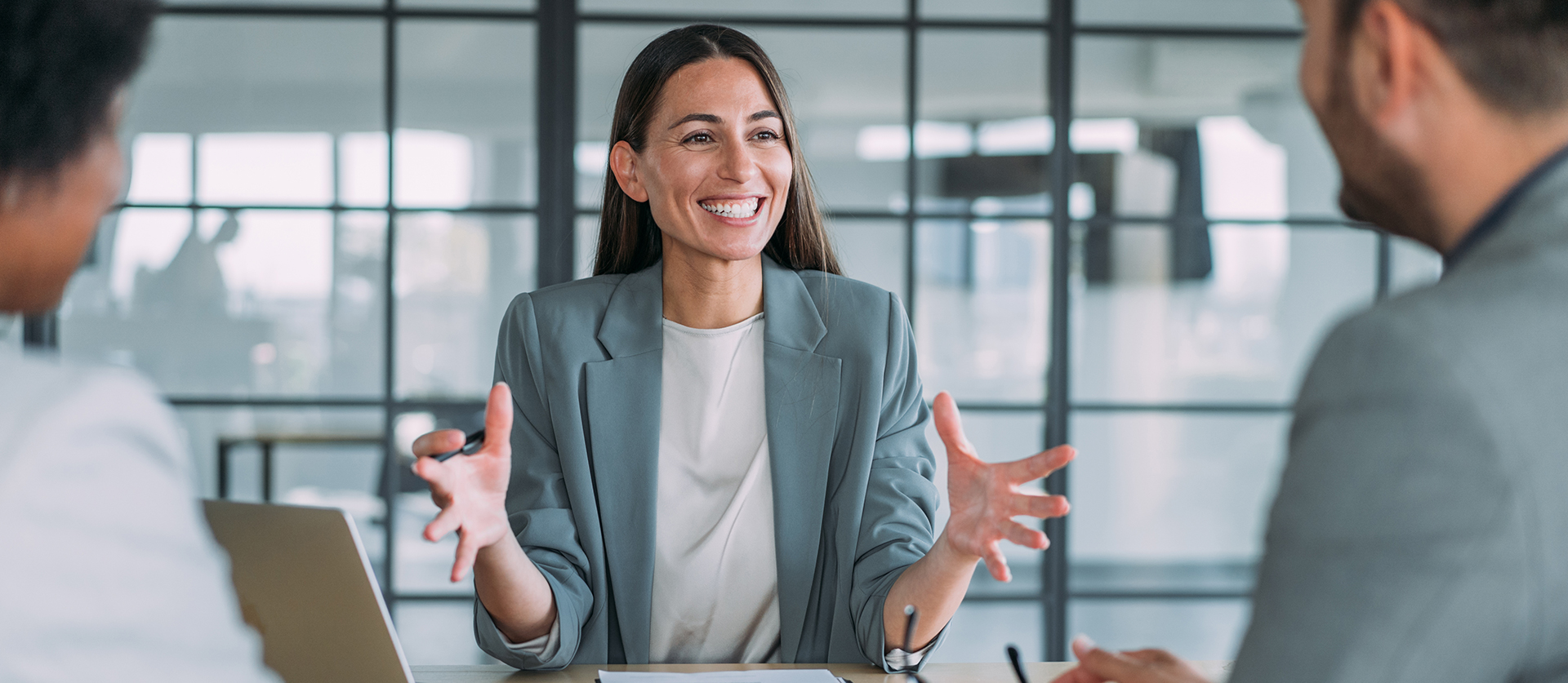 Vrouw zit aan een meeting tafel en leid de meeting