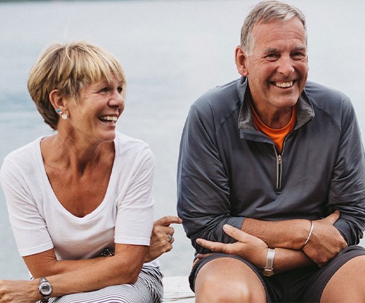 een ouder stel zit naast elkaar te lachen