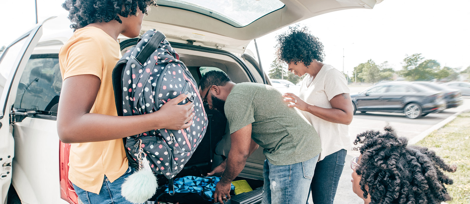 een gezin pakt de kofferbak in