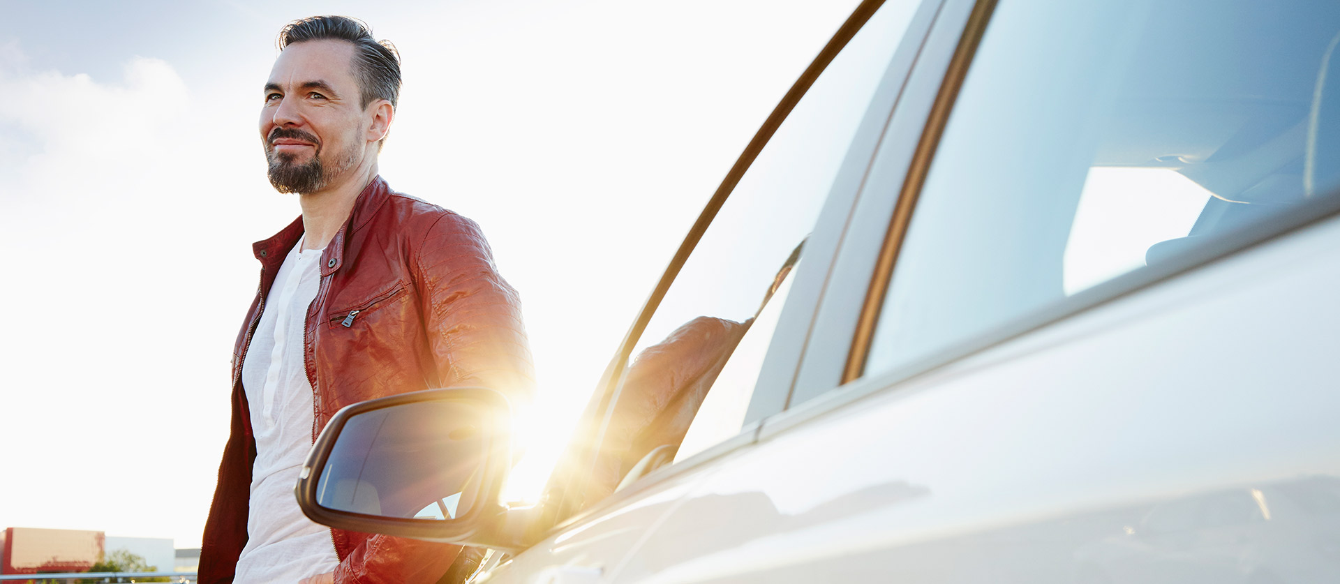 man leunt tegen motorkap auto aan