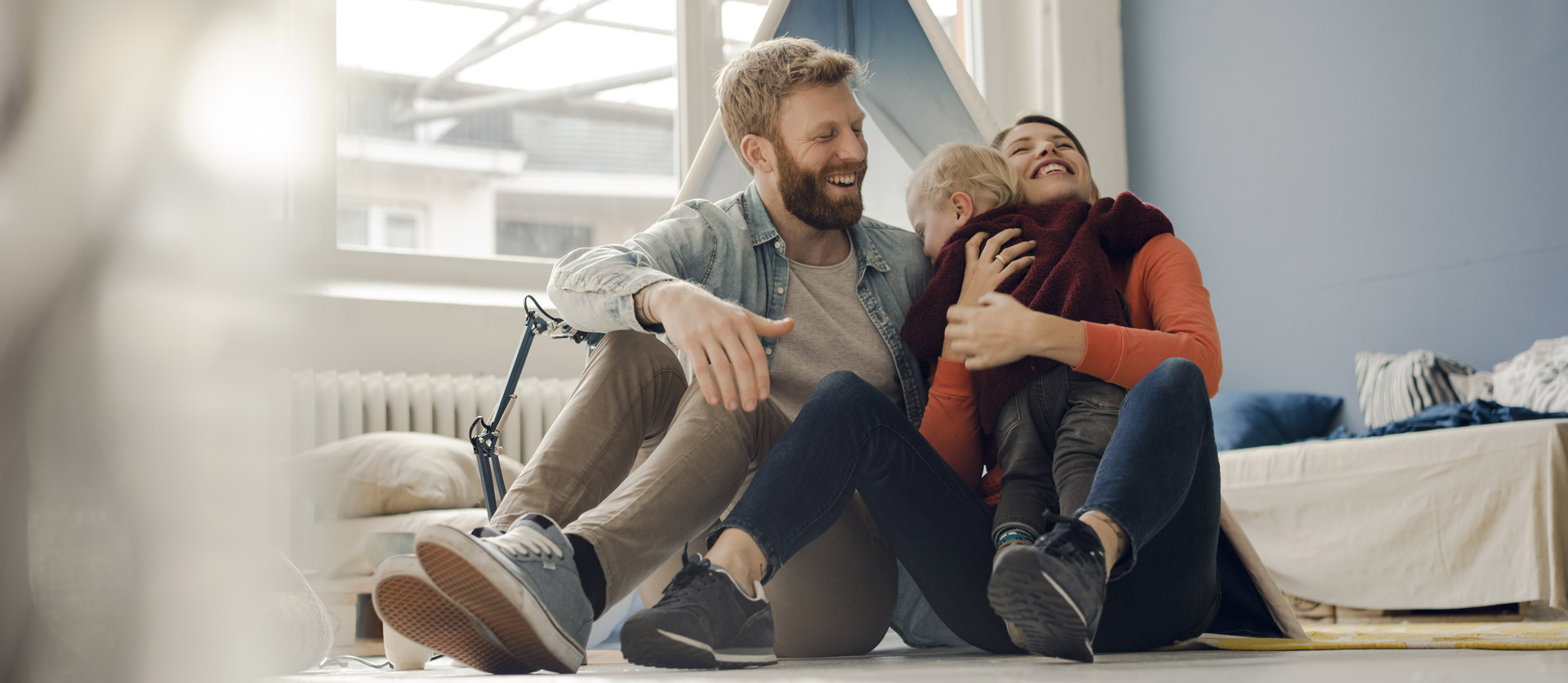 Ouders zitten op de grond en knuffelen hun zoon