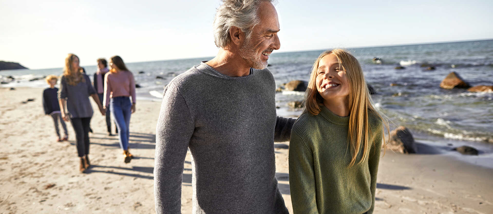vader en dochter lopen samen op het strand