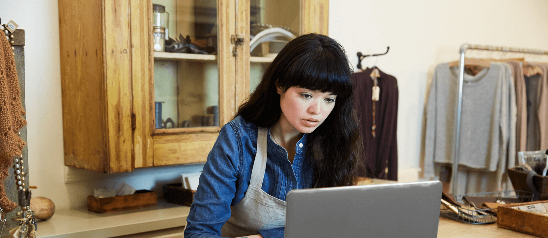 vrouwelijke ondernemer staat achter haar laptop bij de toonbank