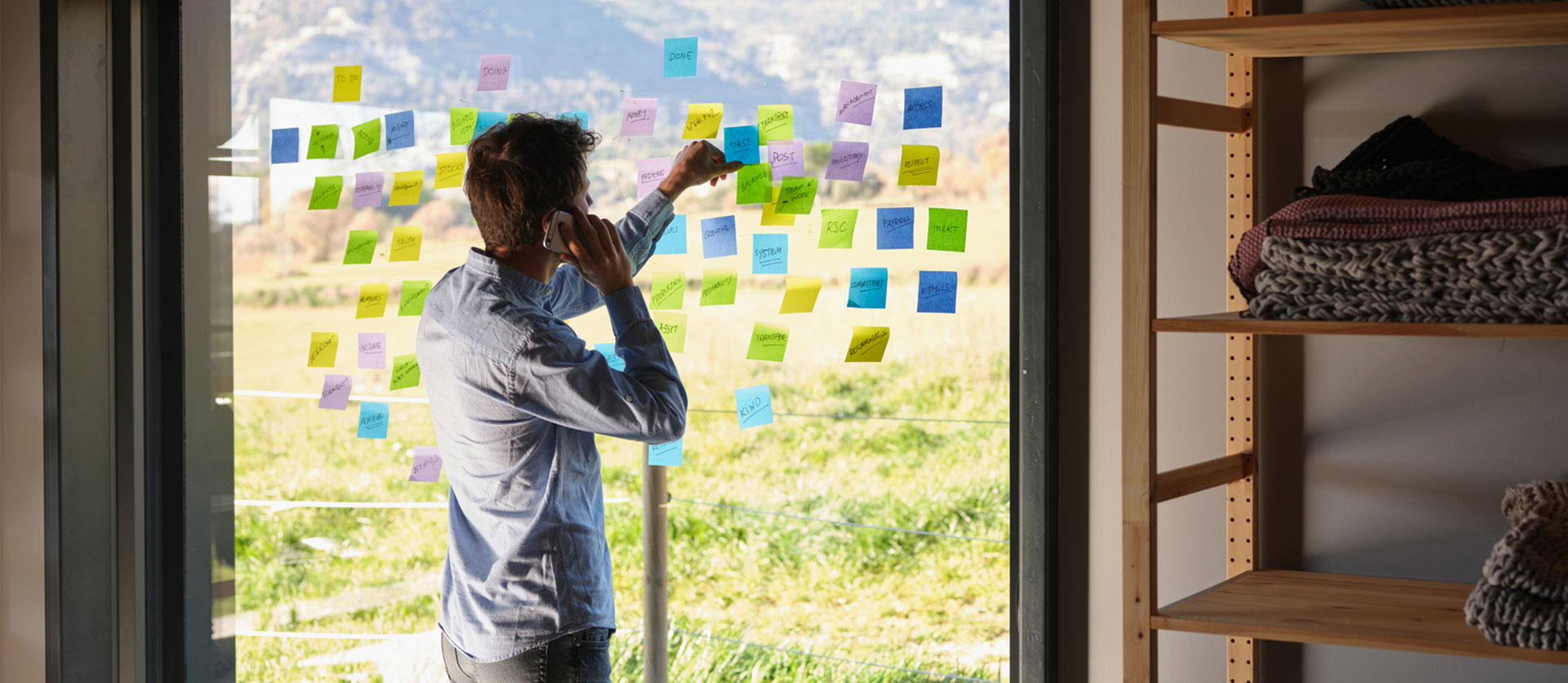 man plakt post-its op een raam