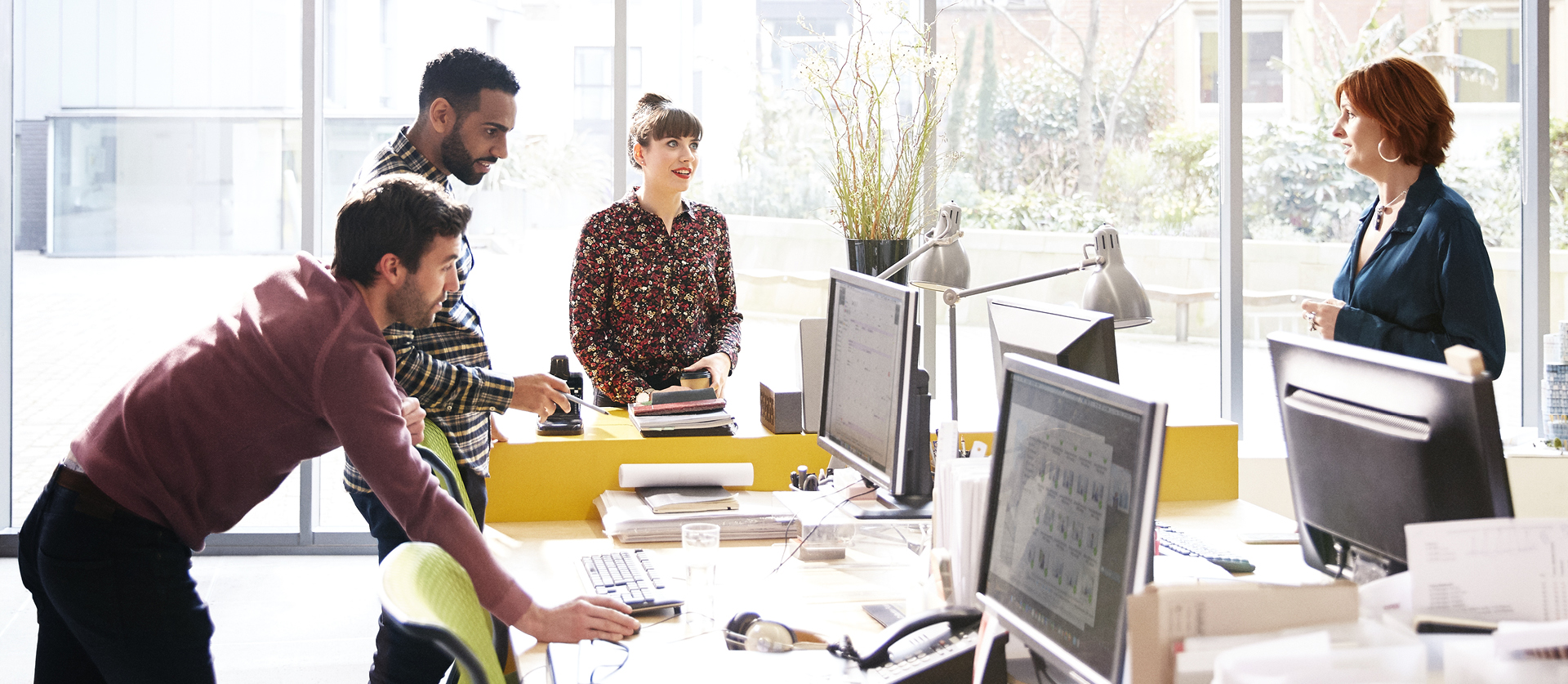 4 collega's staan te overleggen rondom bureau's