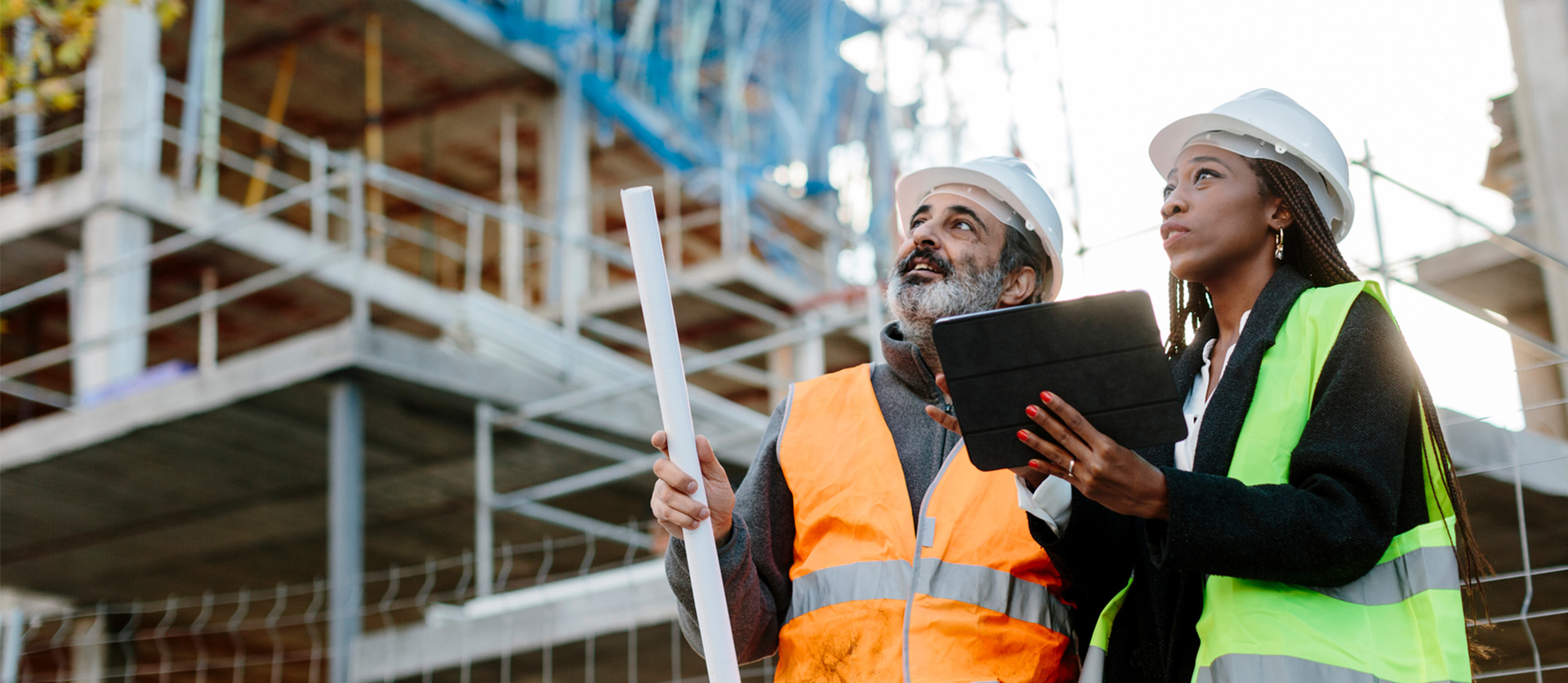 2 bouwvakkers op een bouwplaats kijken naar hun project